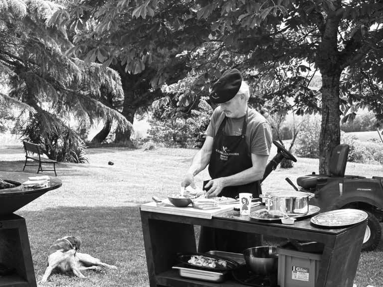 Le chef prépare les plats sur une table en extérieur, photo en noir et blanc