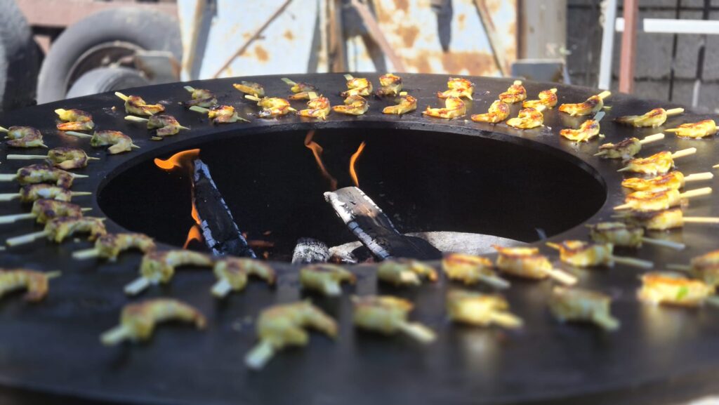 Brochettes en cuisson sur le pourtour du brasero